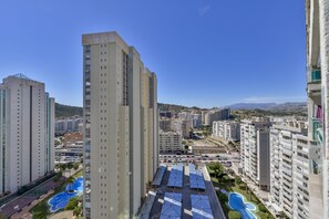 A high-rise building with multiple floors, surrounded by other buildings, and a clear blue sky. - Unique Apartment (La Vila Joiosa)
