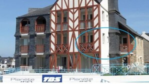 A traditional half-timbered building with multiple balconies and a stone facade. - APARTMENT IN MORBIHAN - DIRECT ACCESS TO THE PORT AND BEACH ON FOOT (Arzon)