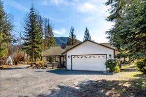Situated in a serene natural setting, this single-story home features a detached garage and a symmetrical design.