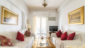 Una sala de estar con dos sofás, una mesa de centro y un televisor.