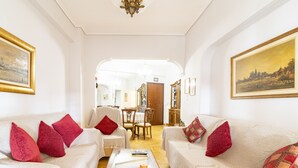 Una sala de estar con dos sofás, una mesa de centro y un área de comedor al fondo.