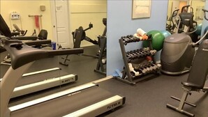 Een sportschool met loopbanden, gewichten en fitnessballen.