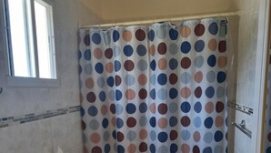 A bathroom with a toilet, sink, and shower curtain with a polka dot pattern. - Cozy Studio Apartment in Quiet Neighborhood (Philipsburg)
