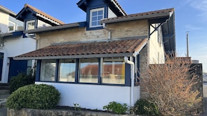 A two-story house with a tiled roof, a bay window, and a stone wall. - RESIDENCE DE LA PLAGE (Bidart)