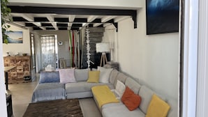 A modern living room with a sectional sofa, wooden coffee table, and a painting on the wall. - RESIDENCE DE LA PLAGE (Bidart)