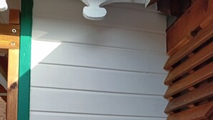 A white wall with horizontal siding and a framed sign that reads "Lodge Ylang Ylang." - Aïchi ´s Lodges (Capesterre-de-Marie-Galante)