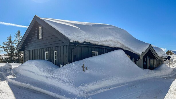 A snow-covered wooden building with a steep roof, surrounded by snow. - Amazing home in Sjusjøen with sauna (Sjusjøen)
