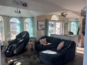 A living room with a massage chair, a dark blue sofa, and a small table.