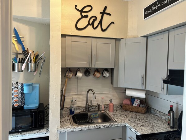 A kitchen with a microwave, sink, and cabinets. - The Posh Plum - 1 Block to the Casino Ballroom, Bars and Beach (Hampton)