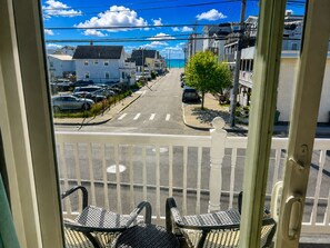 A balcony with a view of a street, cars, and buildings. - The Posh Plum - 1 Block to the Casino Ballroom, Bars and Beach (Hampton)