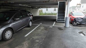 A parking garage with a car parked in a designated space. - The Posh Plum - 1 Block to the Casino Ballroom, Bars and Beach (Hampton)