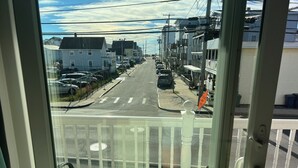 A view from a window overlooking a street with parked cars, buildings, and a clear sky. - The Posh Plum - 1 Block to the Casino Ballroom, Bars and Beach (Hampton)