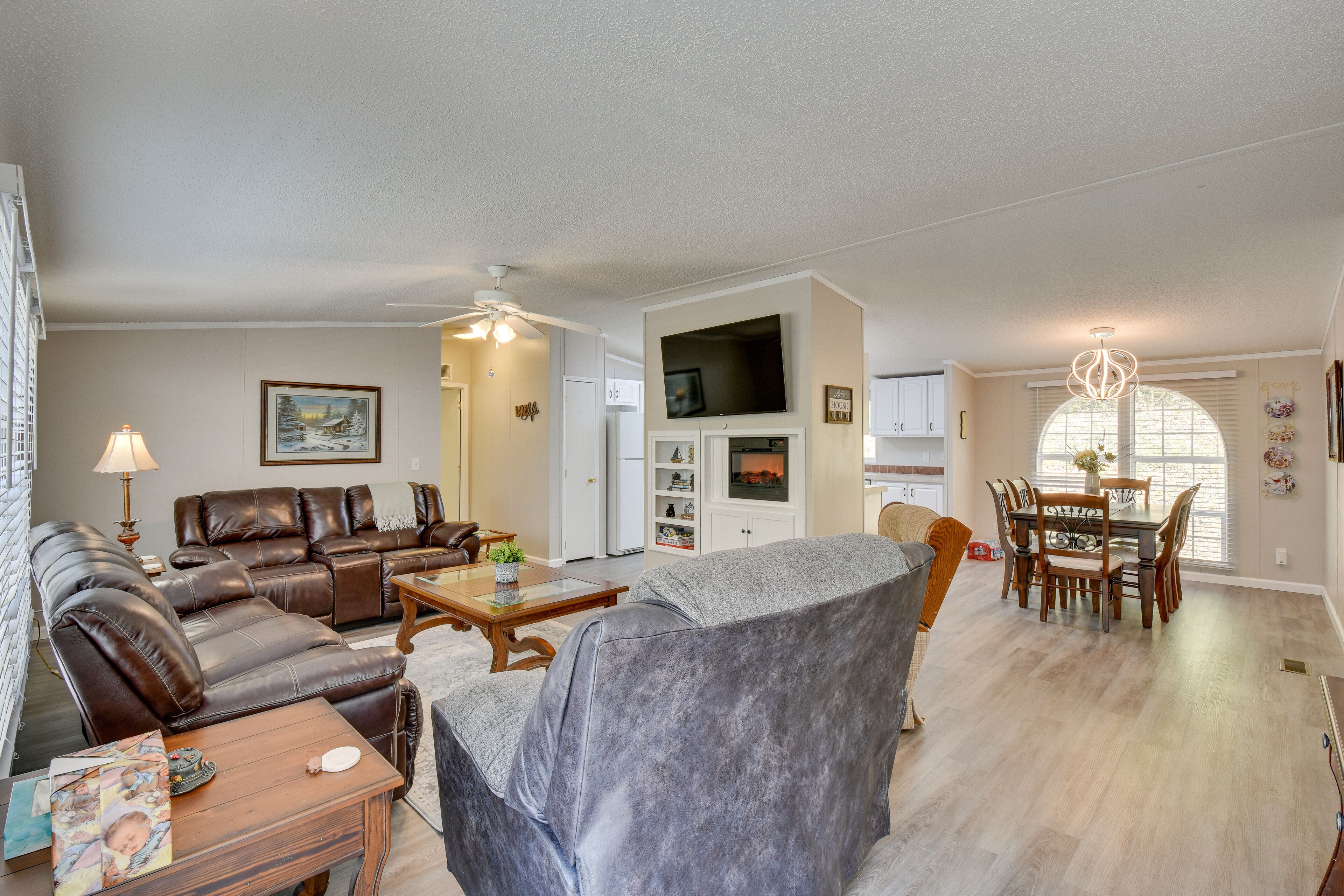 A spacious living room with a fireplace, a dining area, and a kitchen.