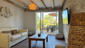 A modern living room with a sofa, a wooden coffee table, and a wicker ottoman. - Villa de Luxe, Hyper Centre, Port de Portovecchio (Porto-Vecchio)