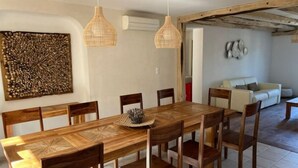 A dining area with a wooden table and chairs, two hanging wicker pendant lights, and a decorative wall piece. - Villa de Luxe, Hyper Centre, Port de Portovecchio (Porto-Vecchio)