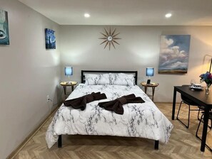Relax in a spacious room with a large bed, two bedside tables, and a desk area.