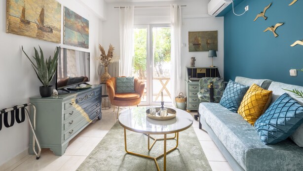 Een woonkamer met een bank, een salontafel, een televisie en een plant.