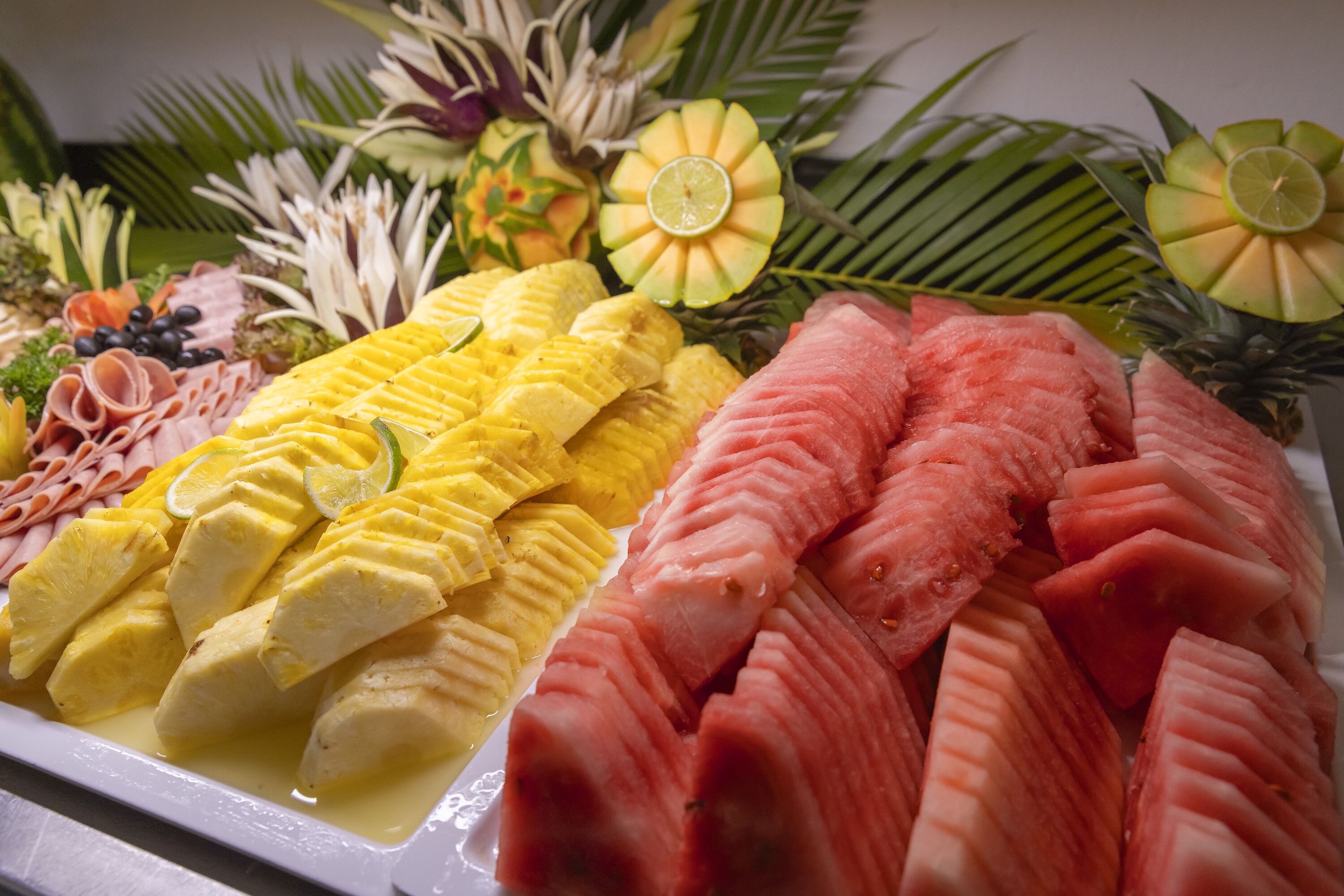 A fruit platter with sliced bananas, watermelon, and pineapple.