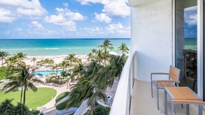 A balcony with a view of a beach, pool, and palm trees. - 504-505 International Resort 2 Bed 2 Ba 1600Sf Ocean View (Sunny Isles Beach)