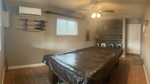 A room with a long table covered with a black tablecloth, a ceiling fan, an air conditioning unit, and a window with blinds. - Quiet spacious home in Cul-de-sac near downtown (Tucson)