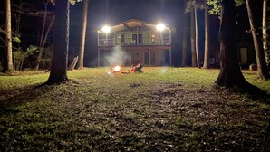 A two-story building with a balcony, surrounded by trees. - Shore Thing Waterfront Home with private covered boat dock on Toledo Bend (Hemphill)