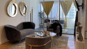 A modern living room with a grey sofa, a round coffee table, and a ceiling fan. - Cozy penthouse Atlanta (Atlanta)