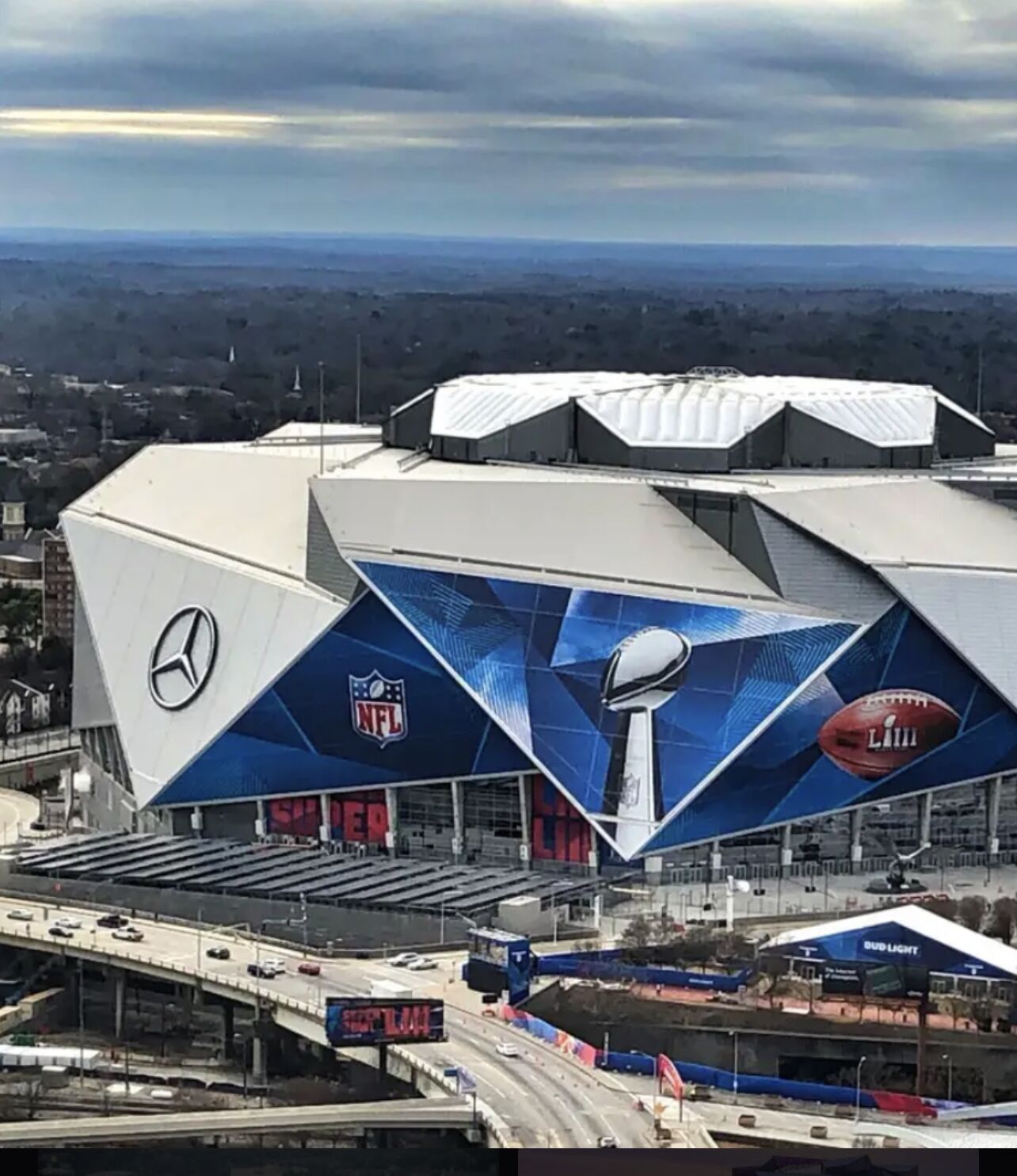 Un estadio con un gran logotipo de Mercedes-Benz, el logotipo de la NFL y un balón de fútbol.