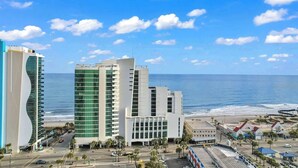 A coastal hotel with multiple buildings, a beach view, and a parking area. - Sandy Beach Resort 1705 - Oceanfront Views (Myrtle Beach)