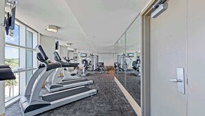 A modern gym with treadmills, weight machines, and a mirrored wall. - Sandy Beach Resort 1705 - Oceanfront Views (Myrtle Beach)