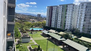 A residential building with a swimming pool, outdoor seating areas, and a view of the surrounding landscape. - Apartment in Ecohousing Phase 2 (Tegucigalpa)