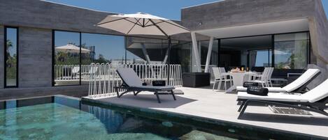Een buitenzwembad en een infinitypool