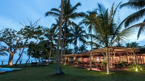 A beachfront resort with outdoor seating and palm trees. - Reserva Jacumã Boutique Hotel  (Porto Seguro)