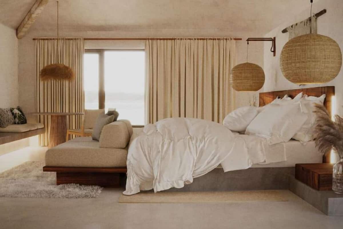 A bedroom with a bed, a sofa, a TV, and a window with curtains.