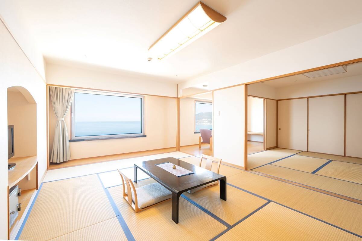 Une pièce de style japonais traditionnel, avec un sol recouvert de tatamis, une table basse et des portes coulissantes.