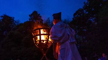 Una persona con toga de graduación sosteniendo un farol encendido.