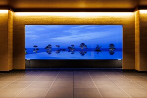 A spacious lobby with a large digital display of a tranquil landscape. - HOTEL OOSADO (Sado)