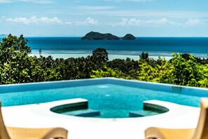 Ein Pool mit Blick auf den Ozean und zwei Inseln.