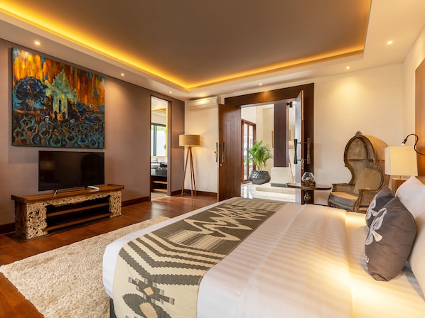 A modern hotel room with a large bed, a flat-screen TV, a painting on the wall, and a view of the outside. - Tirtha Bayu Estate by Elite Havens (Cemagi)
