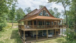 A large wooden cabin with a covered deck and a fire pit. - Top-of-Wisp*6bed/6ba*Hottub* (McHenry)