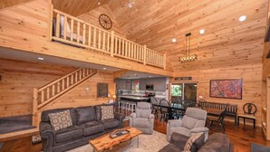 A spacious living area with a wooden interior, a staircase, a kitchen, and a bar area. - Top-of-Wisp*6bed/6ba*Hottub* (McHenry)