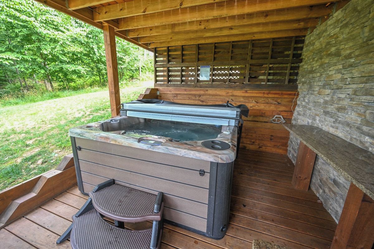 Un jacuzzi con terraza de madera y pared de piedra.