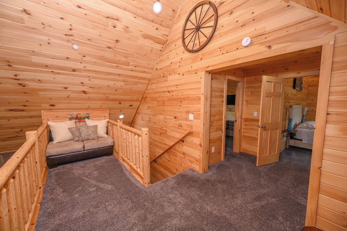 Un intérieur en bois avec un canapé, un volant en bois et un sol recouvert d’une moquette.