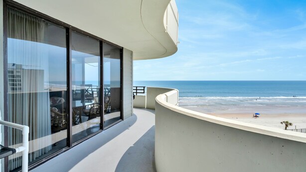 Un balcón con vista a la playa y al océano.