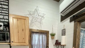 Una cocina con gabinetes de madera, un lavamanos de acero inoxidable, un lavavajillas y una estrella decorativa en la pared.