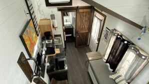 Una cocina compacta y moderna con estufa integrada, un lavamanos y encimera de madera.