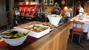 A buffet setup with various dishes, a coffee machine, and a dartboard in the background. - The Exchange Beaconsfield - Offering Heritage Accommodation (Beaconsfield)