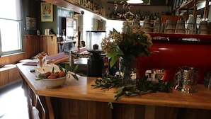 A bar area with a wooden counter, a bowl of fruit, and various bar tools. - The Exchange Beaconsfield - Offering Heritage Accommodation (Beaconsfield)