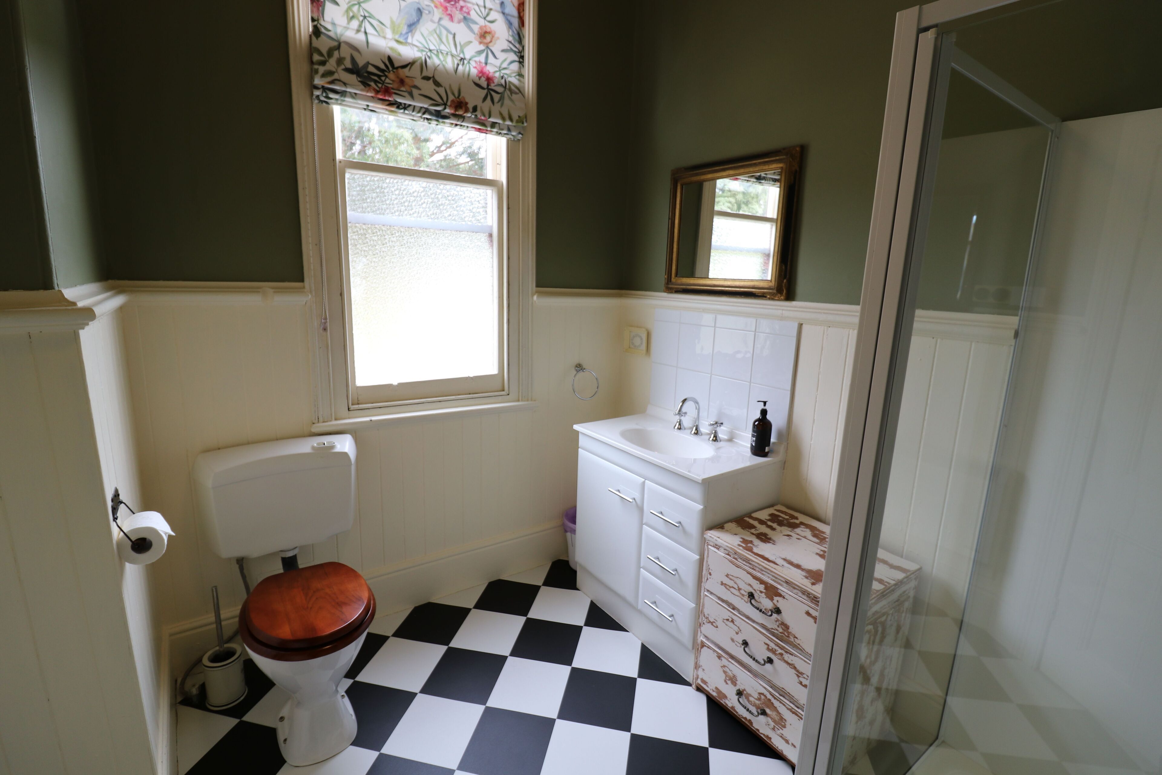 Une salle de bain avec des toilettes, un lavabo et une douche.