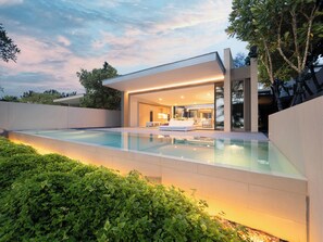 A modern house with a swimming pool, a patio, and a large glass door leading to a living area. - Veyla Natai Residence - Luxury Pool Villa  (Takua Thung)