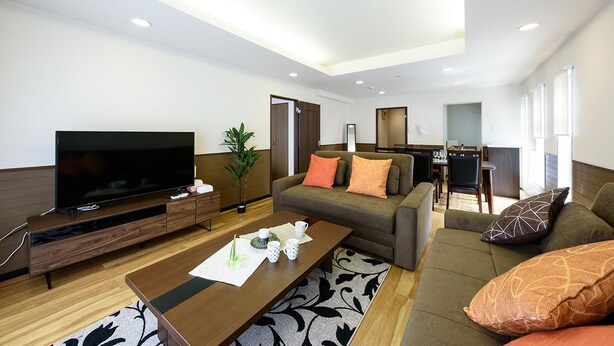 A modern living room with a flat-screen TV, a wooden coffee table, and a sofa set. - Dynasty Nijuyonken (Sapporo)